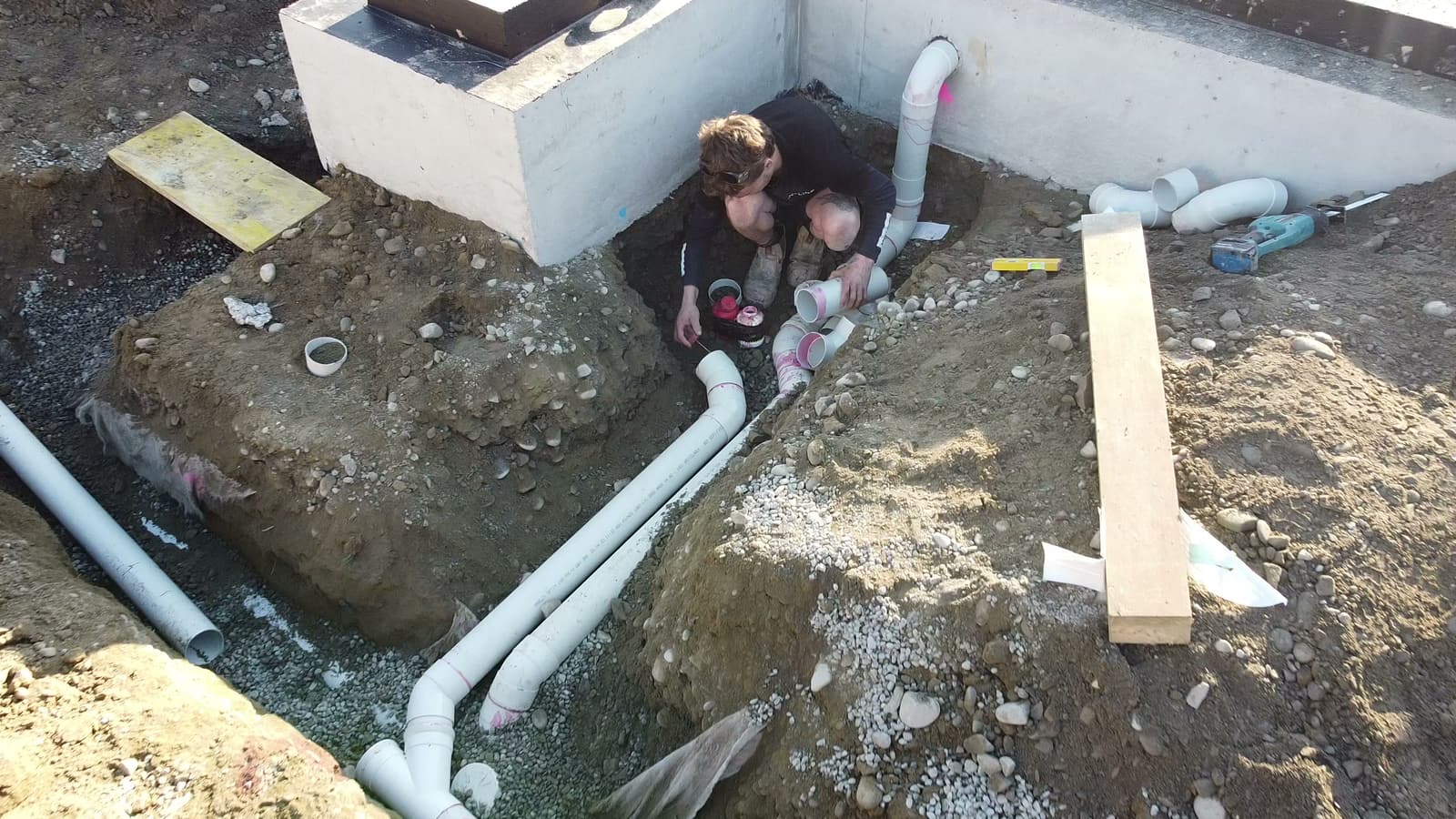 Inline Plumbing team laying PVC drainage pipework beneath a new build slab in Christchurch